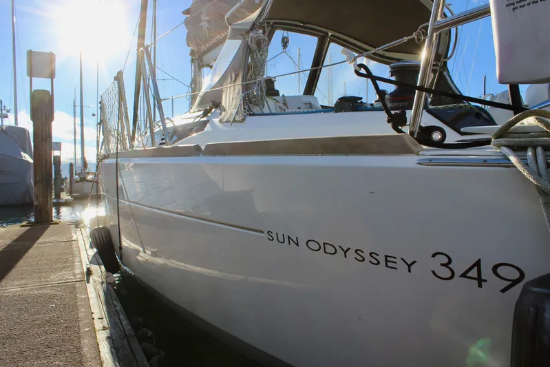 Selkie Yacht Photos Pics 2015 Jeanneau Sun Odyssey 349 sailboat docked in marina, sunlit and ready for sailing.