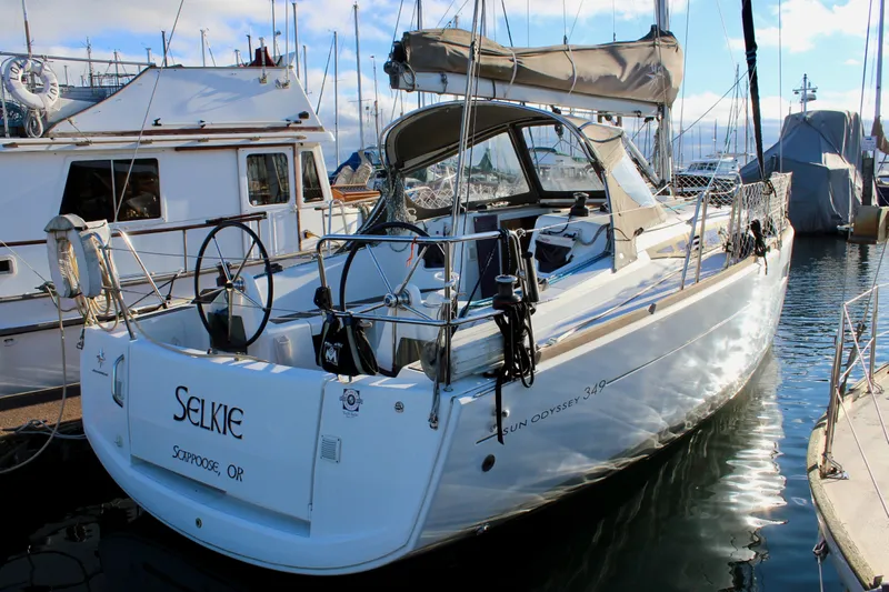 Selkie Yacht Photos Pics 2015 Jeanneau Sun Odyssey 349 sailboat docked in marina, rear view.