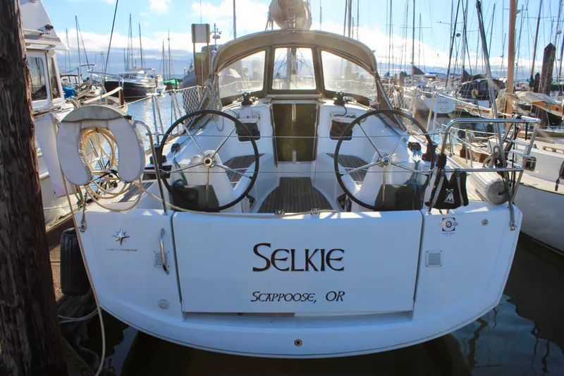 Selkie Yacht Photos Pics 2015 Jeanneau Sun Odyssey 349 sailboat docked, featuring dual steering wheels and "Selkie" name.