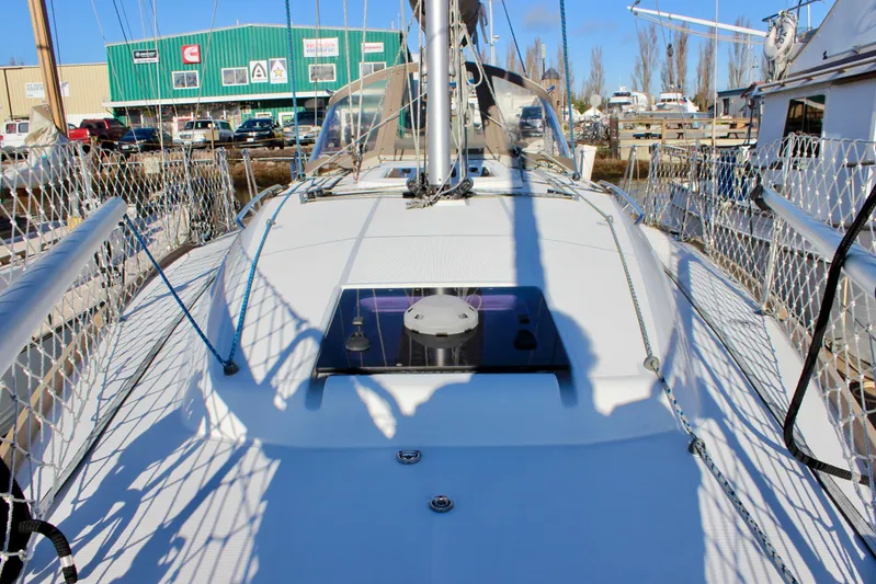 Selkie Yacht Photos Pics 2015 Jeanneau Sun Odyssey 349 sailboat deck with netted railings and marina background.