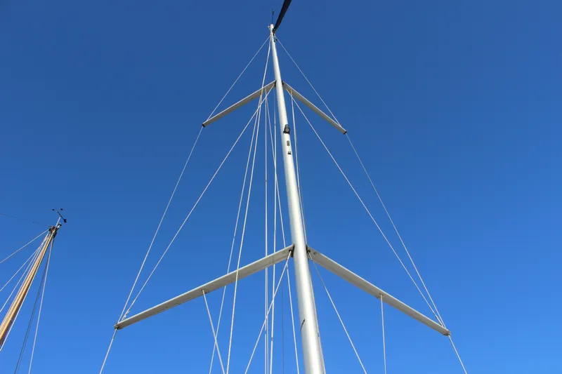 Selkie Yacht Photos Pics Mast of 2015 Jeanneau Sun Odyssey 349 sailboat against clear blue sky.