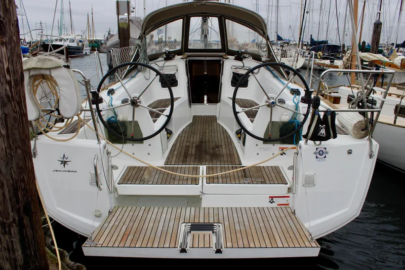 Selkie Yacht Photos Pics 2015 Jeanneau Sun Odyssey 349 sailboat docked at marina, featuring dual steering wheels.