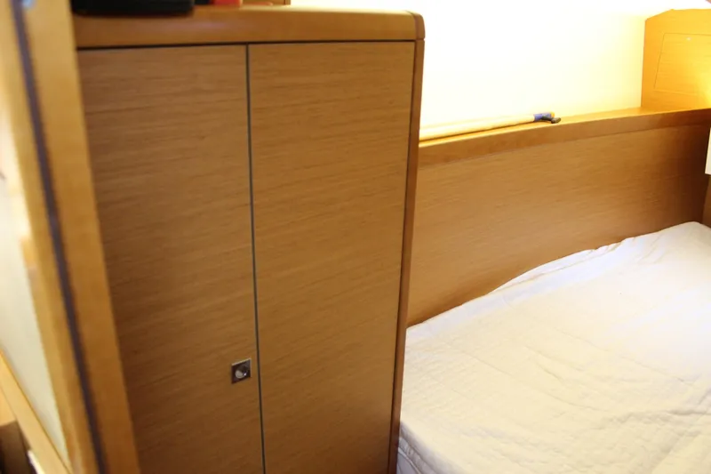 Selkie Yacht Photos Pics Interior cabin of 2015 Jeanneau Sun Odyssey 349 sailboat with wooden cabinetry and bed.