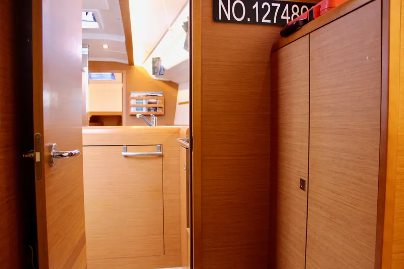 Selkie Yacht Photos Pics Interior of 2015 Jeanneau Sun Odyssey 349 sailboat, featuring wooden cabinetry and modern design.