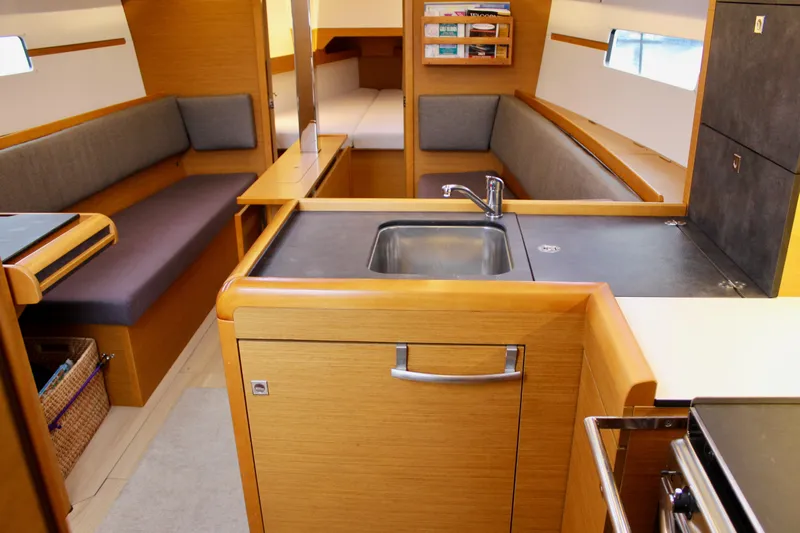 Selkie Yacht Photos Pics Interior of 2015 Jeanneau Sun Odyssey 349 sailboat, featuring a modern kitchen and seating area.