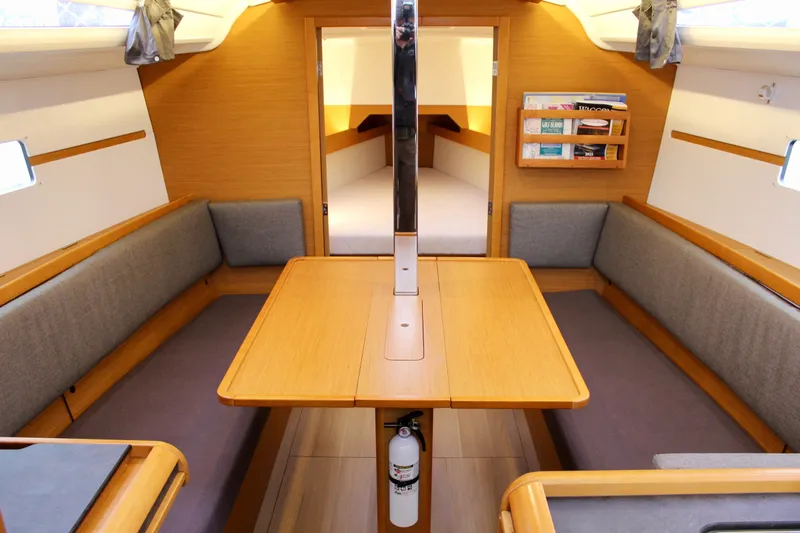 Selkie Yacht Photos Pics Interior of 2015 Jeanneau Sun Odyssey 349 sailboat with cozy seating and wooden table.