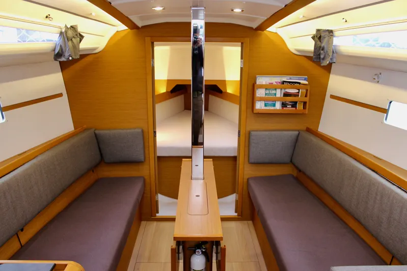 Selkie Yacht Photos Pics Interior of 2015 Jeanneau Sun Odyssey 349 sailboat, featuring cozy seating and wooden finishes.