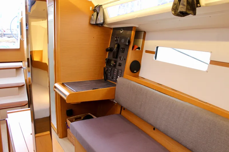Selkie Yacht Photos Pics Interior of 2015 Jeanneau Sun Odyssey 349 sailboat with navigation station and seating area.