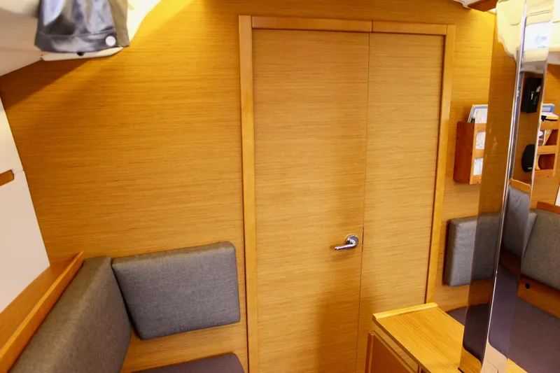 Selkie Yacht Photos Pics Interior of 2015 Jeanneau Sun Odyssey 349 sailboat with wooden finish and gray cushions.