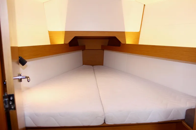 Selkie Yacht Photos Pics Cabin interior of 2015 Jeanneau Sun Odyssey 349 sailboat with cozy bedding.