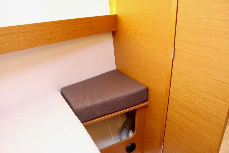 Selkie Yacht Photos Pics Interior of 2015 Jeanneau Sun Odyssey 349, featuring wooden cabinetry and cushioned seating.