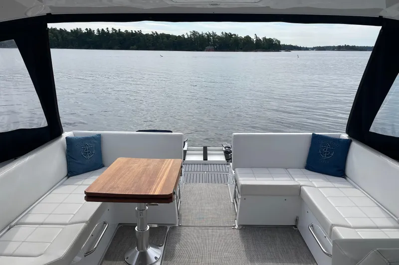  Yacht Photos Pics 2019 Cruisers Yachts 390 Express Coupe interior with lake view, featuring white seating and wooden table.