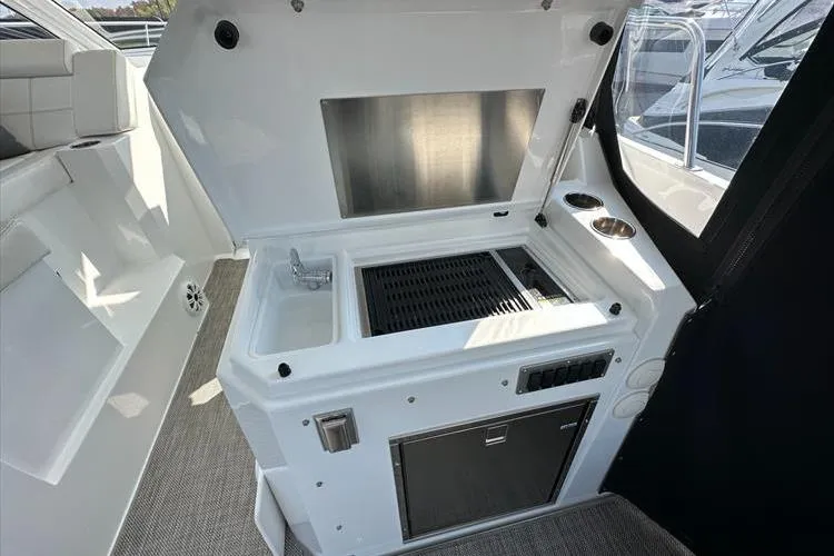 Yacht Photos Pics 2019 Cruisers Yachts 390 Express Coupe outdoor kitchenette with sink and grill.