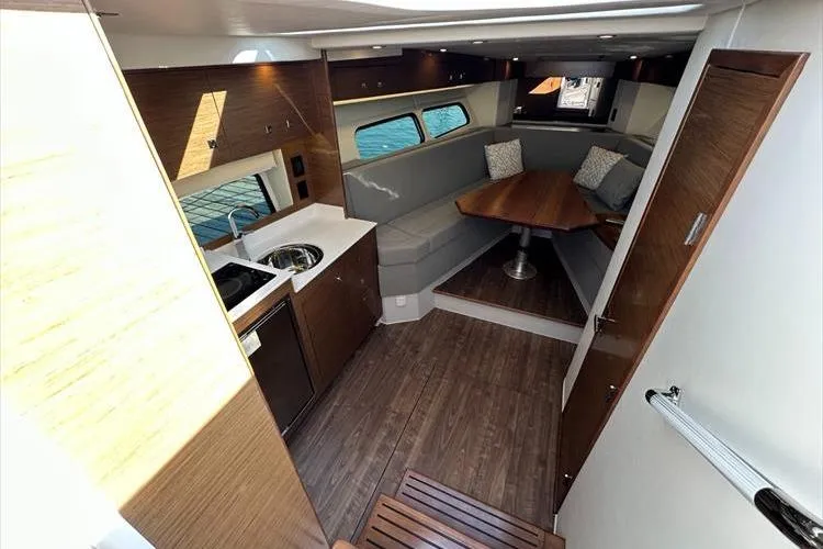  Yacht Photos Pics 2019 Cruisers Yachts 390 Express Coupe interior with modern kitchen and cozy seating area.