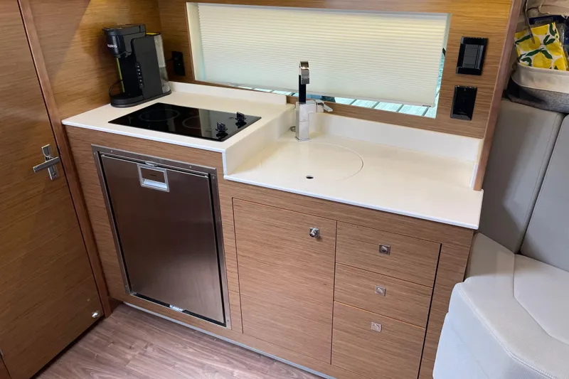  Yacht Photos Pics 2019 Cruisers Yachts 390 Express Coupe kitchen with stove, sink, and modern cabinetry.