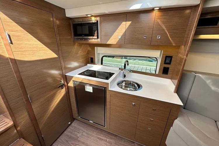  Yacht Photos Pics Modern kitchen interior of 2019 Cruisers Yachts 390 Express Coupe with wood finish.