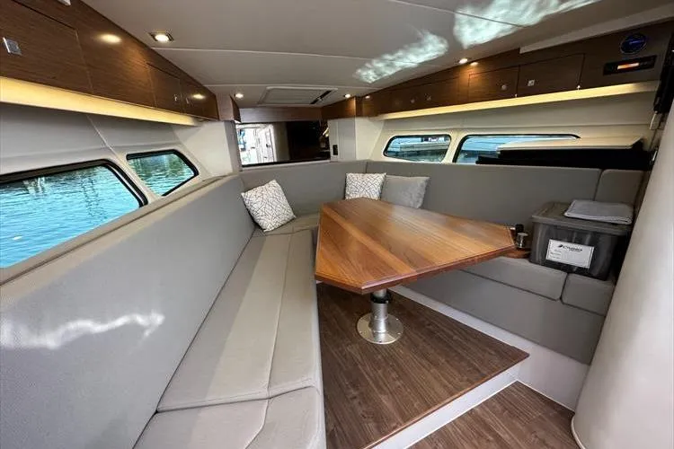  Yacht Photos Pics 2019 Cruisers Yachts 390 Express Coupe interior with elegant seating and wooden table.