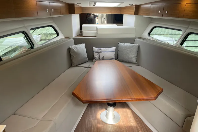  Yacht Photos Pics 2019 Cruisers Yachts 390 Express Coupe interior with elegant seating and wooden table.