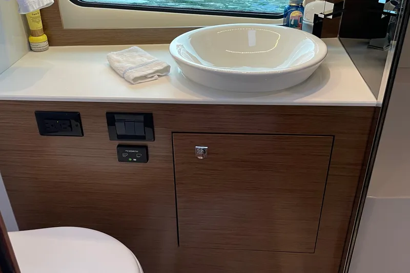  Yacht Photos Pics 2019 Cruisers Yachts 390 Express Coupe bathroom with modern sink and wooden cabinetry.