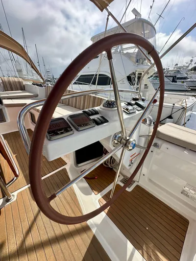 Stella Maris Yacht Photos Pics Jeanneau 57 yacht helm, 2014 model, featuring a sleek wooden steering wheel and modern navigation instruments.