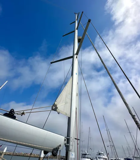 Stella Maris Yacht Photos Pics Mast of 2014 Jeanneau 57 sailboat against a cloudy blue sky.