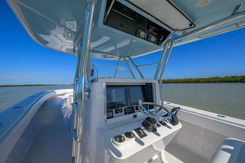 Grand Slam Yacht Photos Pics 2017 Bahama 41 boat cockpit with steering wheel and navigation equipment on a sunny day.