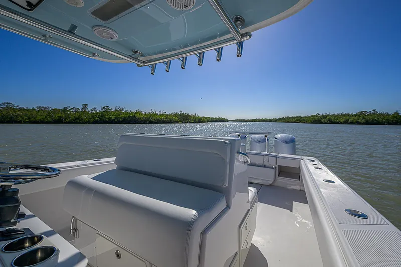 Grand Slam Yacht Photos Pics 2017 Bahama 41 boat on calm water, clear sky, lush green shoreline.