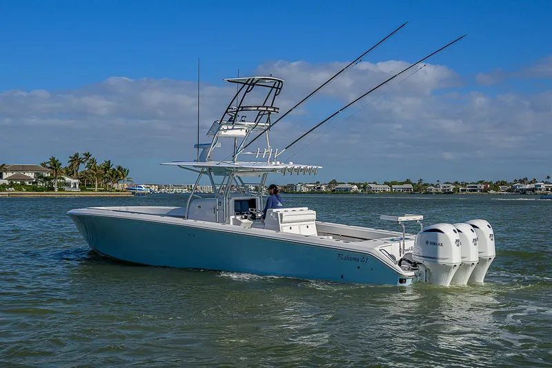 Grand Slam Yacht Photos Pics 2017 Bahama 41 boat on water with triple outboard engines, clear sky background.