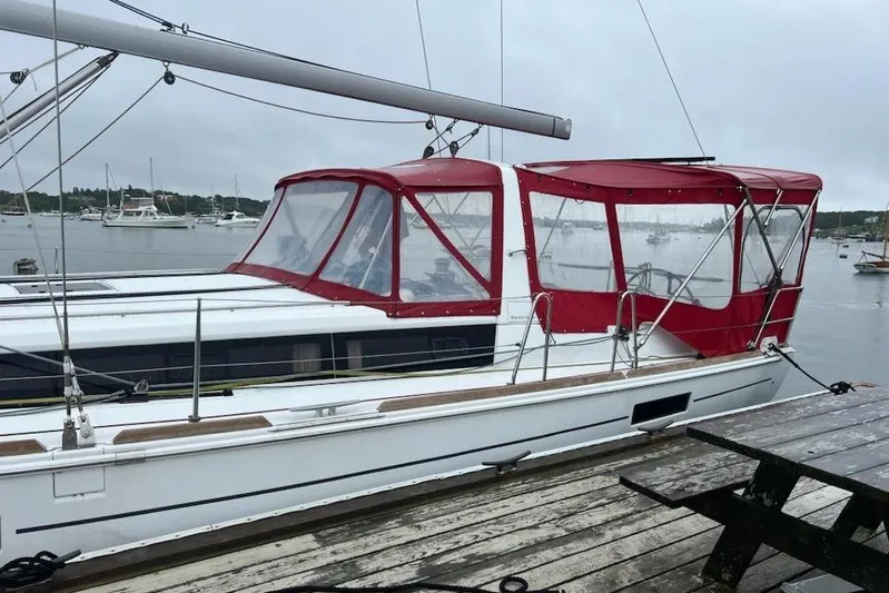  Yacht Photos Pics 2013 Beneteau Oceanis 45 sailboat with red canopy docked in a marina.