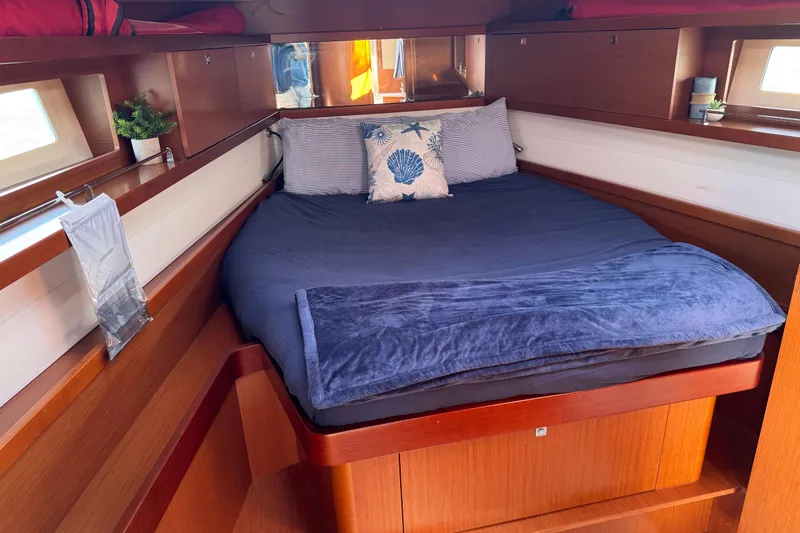  Yacht Photos Pics Cozy cabin interior of 2013 Beneteau Oceanis 45 with plush bedding and wooden finish.