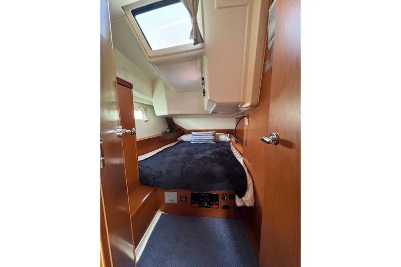  Yacht Photos Pics Cozy cabin interior of 2013 Beneteau Oceanis 45 sailboat with skylight and wooden finishes.