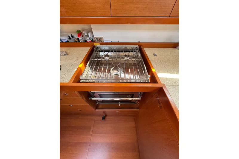  Yacht Photos Pics Galley kitchen in 2013 Beneteau Oceanis 45 yacht with stove and wooden cabinetry.
