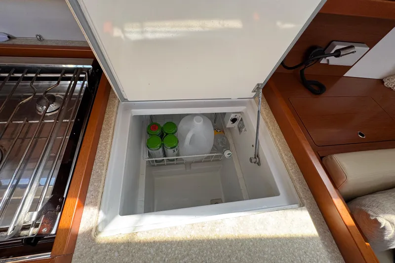 Yacht Photos Pics Beneteau Oceanis 45 yacht kitchen with open fridge, showcasing beverages and storage.