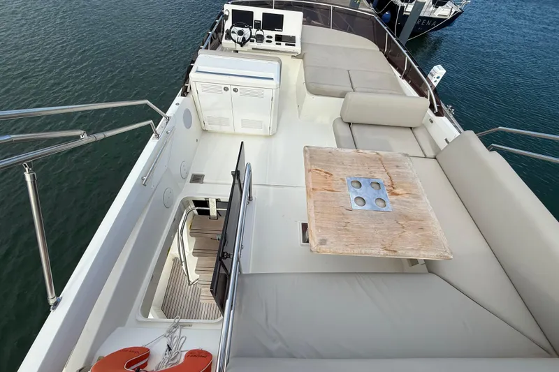  Yacht Photos Pics 2020 Prestige 520 yacht deck with seating, table, and helm station on calm water.