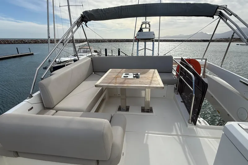  Yacht Photos Pics Luxurious 2020 Prestige 520 yacht deck with seating and table, overlooking serene marina.