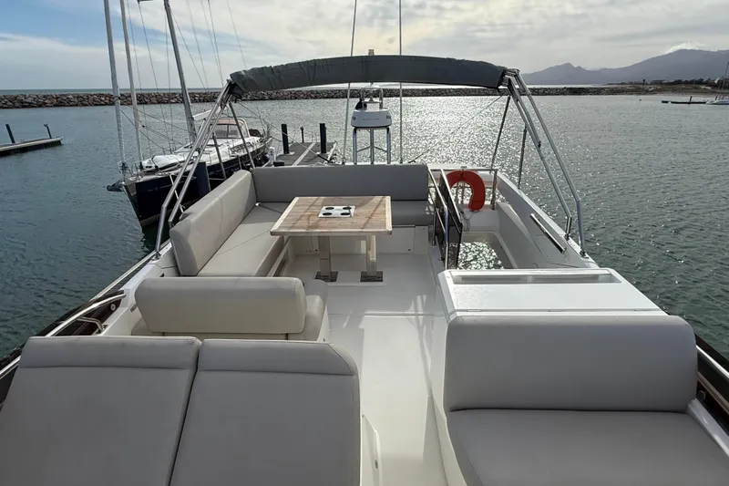  Yacht Photos Pics 2020 Prestige 520 yacht deck with seating and table, docked in a marina.