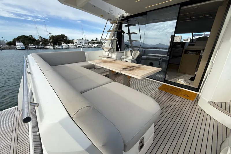  Yacht Photos Pics Luxury 2020 Prestige 520 yacht deck with seating and table, docked at marina.