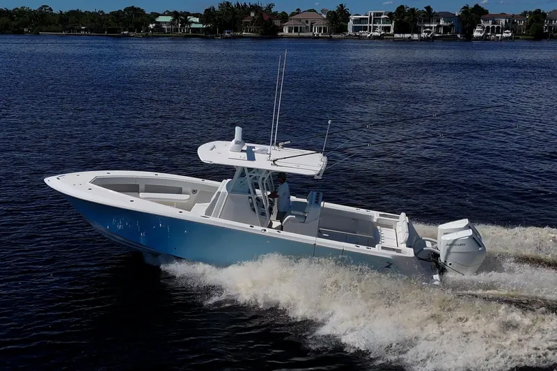 Da Bubbs Yacht Photos Pics 2024 SeaVee 322z boat cruising on a calm river with waterfront homes in the background.