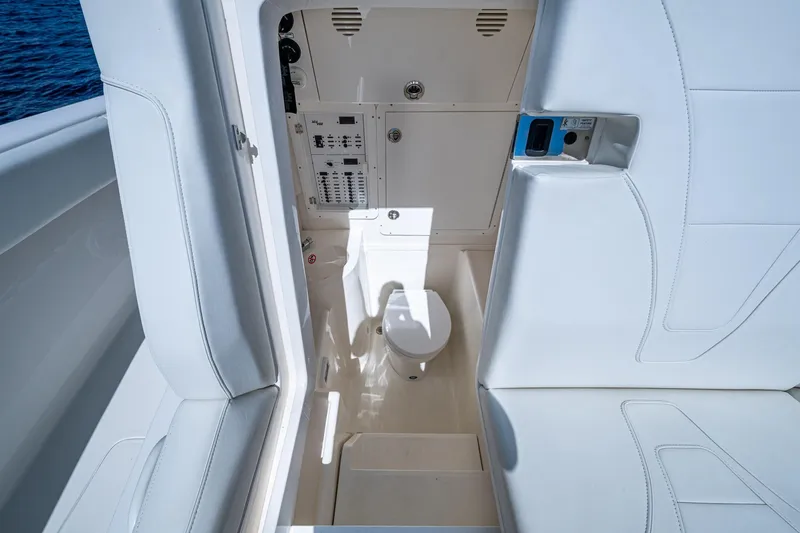 Da Bubbs Yacht Photos Pics 2024 SeaVee 322z boat interior with white seating and compact marine toilet.