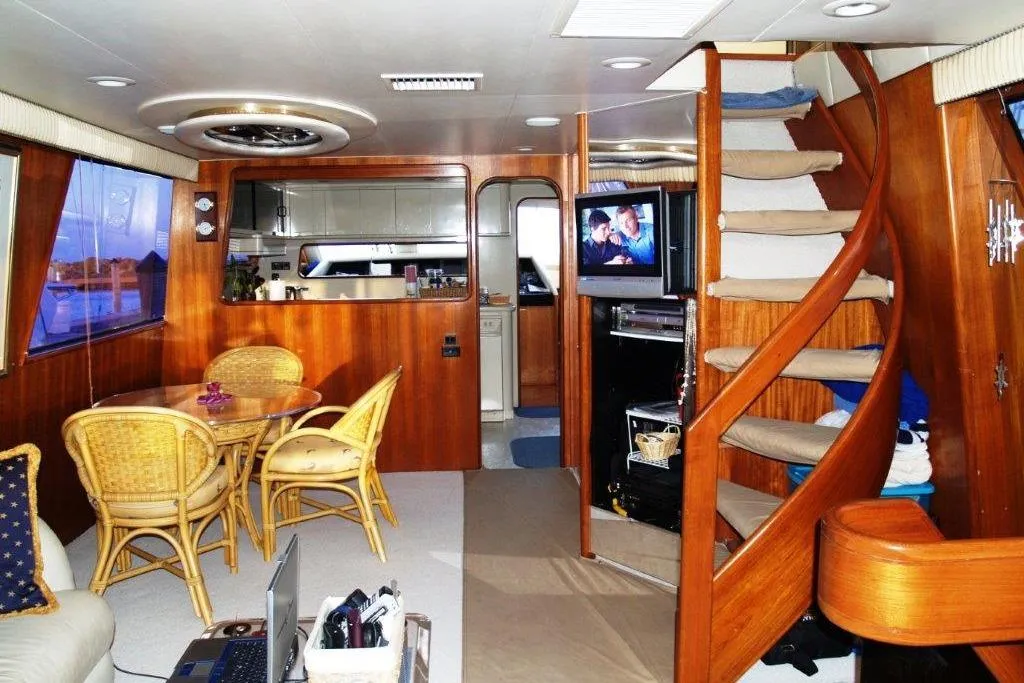 Luxurious interior of 1991 Viking 65 Cockpit yacht with wooden decor and spiral staircase.