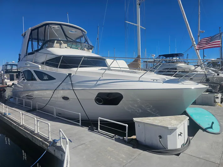Captain's Quarters Yacht Photos Pics 2012 Silverton West Coast Edition yacht docked at marina under clear blue sky.