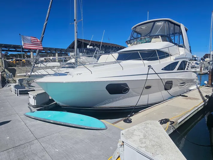 Captain's Quarters Yacht Photos Pics 2012 Silverton West Coast Edition yacht docked at marina with American flag.