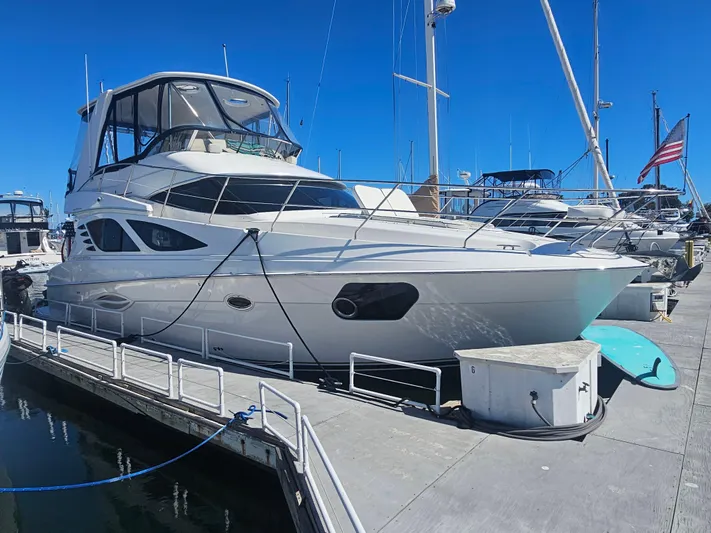 Captain's Quarters Yacht Photos Pics 2012 Silverton West Coast Edition yacht docked at marina under clear blue sky.