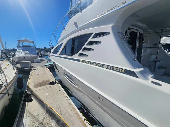 Captain's Quarters Yacht Photos Pics 2012 Silverton West Coast Edition yacht docked at marina under clear blue sky.