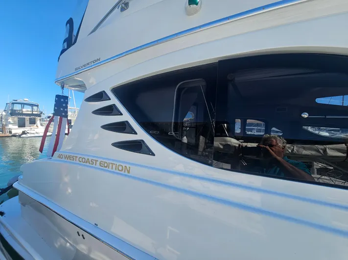 Captain's Quarters Yacht Photos Pics 2012 Silverton West Coast Edition yacht docked, featuring sleek design and American flag.