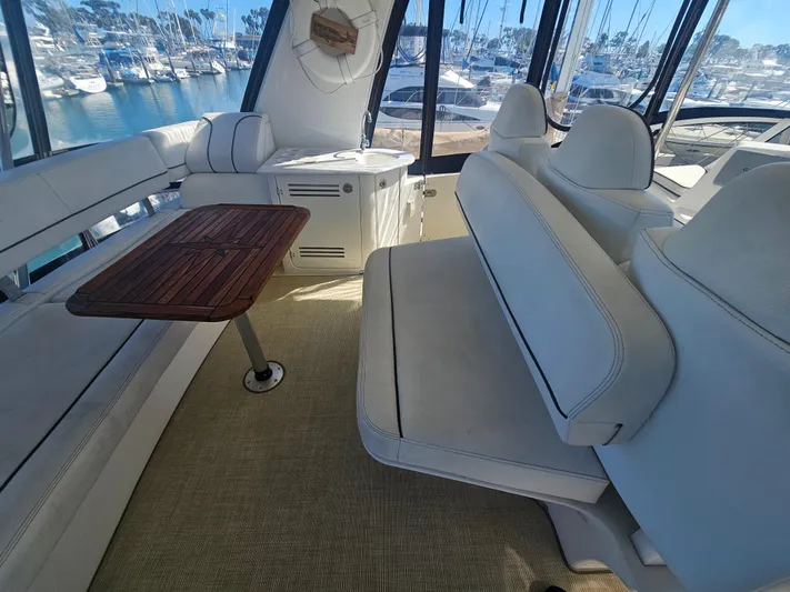 Captain's Quarters Yacht Photos Pics Luxurious 2012 Silverton West Coast Edition yacht interior with white seating and wooden table.