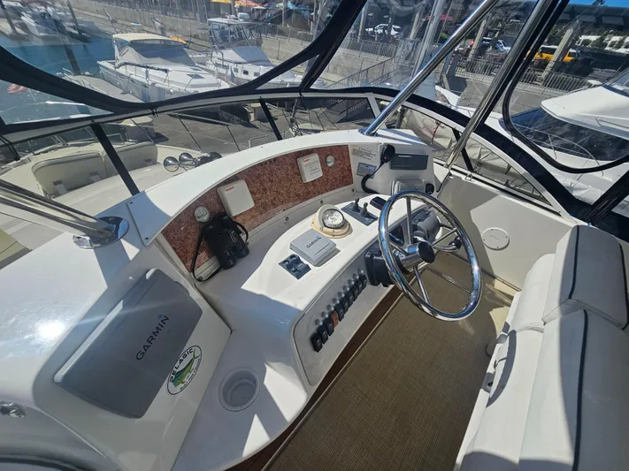 Captain's Quarters Yacht Photos Pics Helm of 2012 Silverton West Coast Edition yacht with steering wheel and navigation equipment.