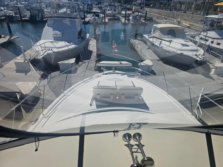 Captain's Quarters Yacht Photos Pics 2012 Silverton West Coast Edition yacht docked at a marina, surrounded by other boats.