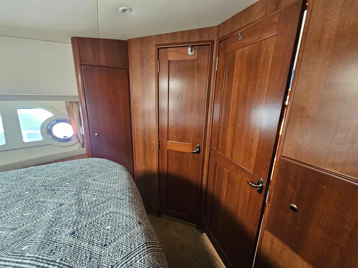 Captain's Quarters Yacht Photos Pics Interior of 2012 Silverton West Coast Edition yacht with wooden cabinetry and porthole window.