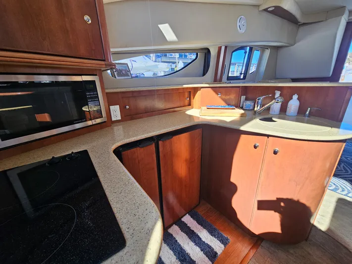 Captain's Quarters Yacht Photos Pics 2012 Silverton West Coast Edition yacht kitchen with microwave, stove, and sink.